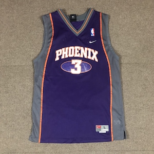 May include: Purple basketball jersey with the word "PHOENIX" and the number "3" on the front. The jersey has gray side panels and a Nike logo on the top right.