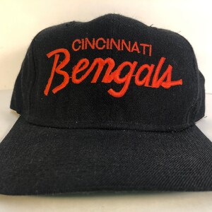 May include: A black baseball cap with the text "Cincinnati Bengals" embroidered in orange on the front.