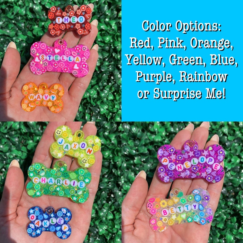May include: A collection of colorful, bone-shaped pet tags with names spelled out in letter beads. The tags feature various designs and colors, including red, pink, orange, yellow, green, blue, purple, and rainbow. Text on the image lists color options.