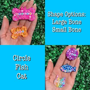 May include: A collection of colorful pet tags in various shapes, including bone, circle, fish, and cat. The tags feature names and decorative elements. Text on the image reads "Shape Options: Large Bone, Small Bone, Circle, Fish, Cat."