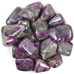 May include: A collection of tumbled pink and grey ruby in zoisite stones. The stones are smooth and polished, with a variety of shapes and sizes.