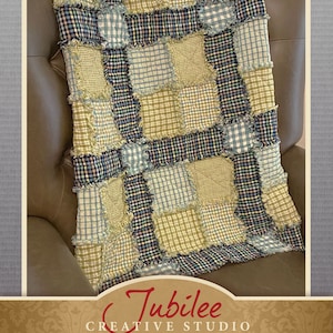 Pode incluir: Uma colcha de retalhos em tons de verde, azul e creme, com um design de borda desfiada. A colcha está sobre uma cadeira de couro marrom. O texto "Neighborly Quilted Throw Pattern" é visível.