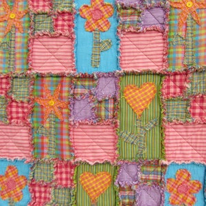 May include: A patchwork quilt with a variety of colorful fabrics and patterns. The quilt features a repeating design of flowers and hearts.