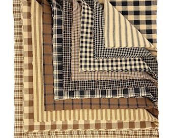 May include: A stack of square fabric swatches featuring various patterns including black and tan buffalo check, brown and cream stripes, and small black and tan gingham checks. Each piece of fabric has raw, frayed edges and a woven texture.