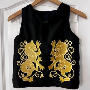 May include: Black sleeveless vest with a gold embroidered design of two lions facing each other.