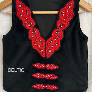 May include: Black velvet waistcoat with red Celtic knot embroidery and rhinestones. The waistcoat has a V-neck and three rows of embellishment on the front. The word "CELTIC" is printed on the front of the waistcoat.