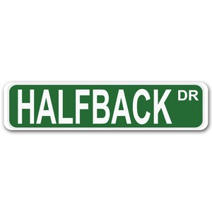 Puede incluir: Señal de calle verde con texto blanco que dice "HALFBACK DR".