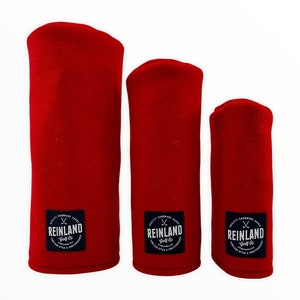 May include: Three red golf club head covers with black and white logos that say "Reinland Golf Co."