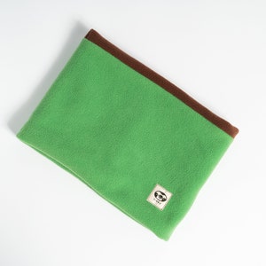 Puede incluir: Cuello de forro polar verde con ribete marr&oacute;n. El calentador de cuello tiene un peque&ntilde;o parche cuadrado con un gr&aacute;fico. Dise&ntilde;ado para mantener el cuello caliente en climas fr&iacute;os.