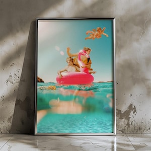 Könnte beinhalten: Gerahmter Kunstdruck mit einer surrealen Szene von Figuren auf einem rosa Flamingo-Schwimmring in türkisfarbenem Wasser. Eine Ananas schwimmt in der Nähe, und Engel fliegen im blauen Himmel. Das Bild hat eine Vintage-Ästhetik.
