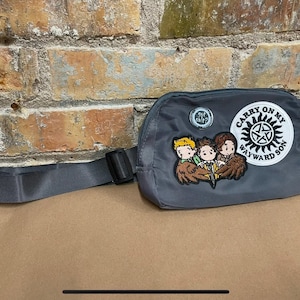 May include: Gray fanny pack with an embroidered patch that says "Carry On My Wayward Son" and features three cartoon characters. The patch is surrounded by a white circle with a black star in the center.
