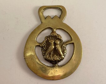 Old and rare harness or bridle medallion for horse decoration of birds in their brass nest