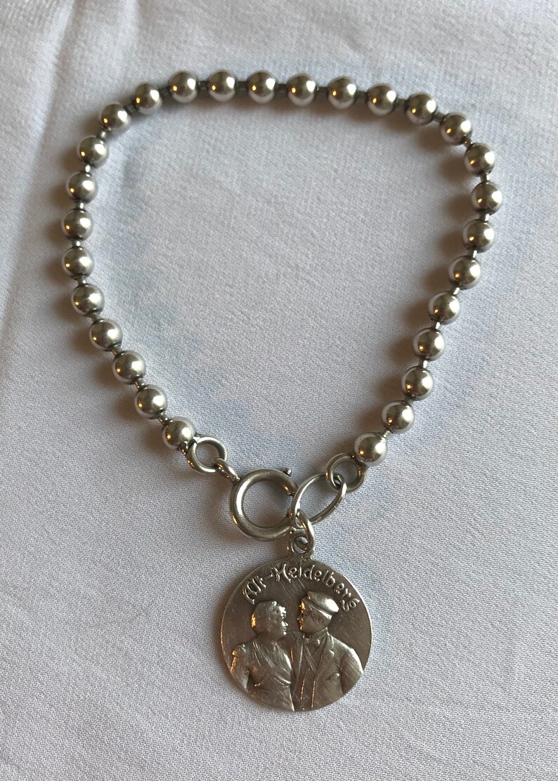 Silver pearl bracelet with 1909 medallion