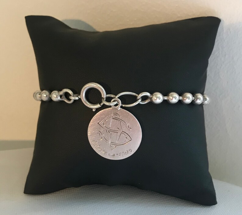 Silver pearl bracelet with 1909 medallion