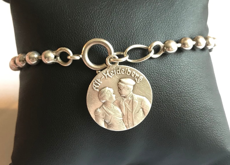 Silver pearl bracelet with 1909 medallion