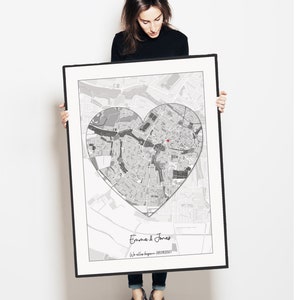 May include: A black and white map of a city with a heart shape drawn around it. The text "Emma & Jonas" and "We all began 08/09/2007" is printed below the map.