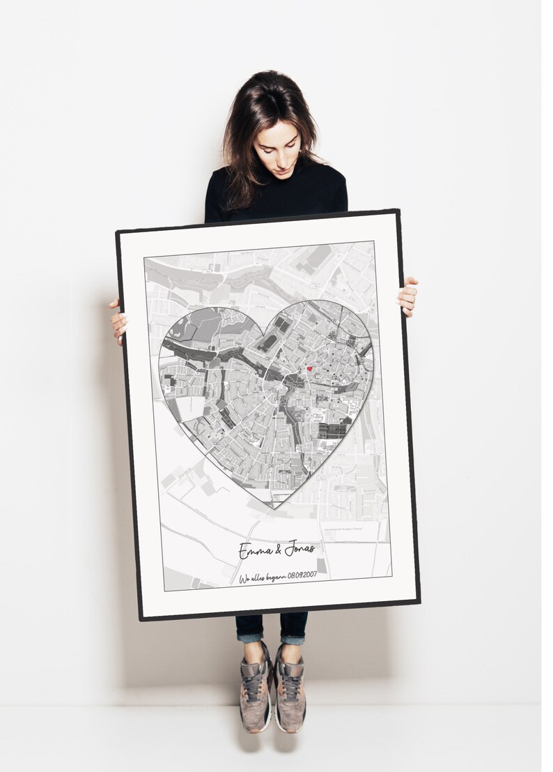 May include: A black and white map of a city with a heart shape drawn around it. The text "Emma & Jonas" and "We all began 08/09/2007" is printed below the map.