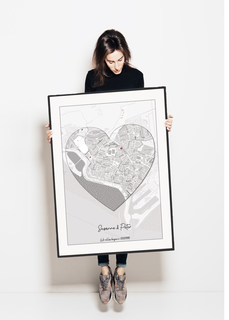 May include: A black and white map print with a heart-shaped outline around a city. The text "Susanne & Peter" and "We all began..." is at the bottom of the print.