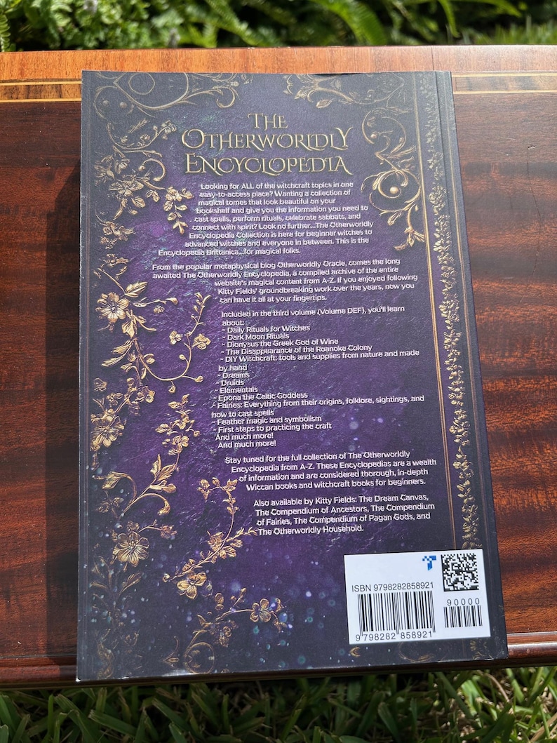May include: The Otherworldly Encyclopedia book, volume DEF, with a dark purple cover and gold floral accents. The back cover features text about witchcraft topics, rituals, and spells. ISBN 9798282858921.