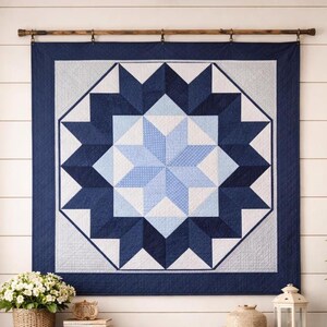 May include: A navy blue and light blue star quilt hanging on a wooden rod. The quilt features a large star design in shades of blue and white, with a navy blue border. The quilt is displayed against a white wall.