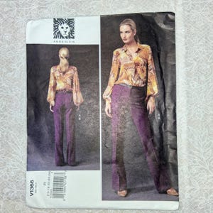 May include: A sewing pattern envelope for an Anne Klein outfit featuring a long-sleeved, patterned yellow and orange blouse paired with solid purple trousers. The front shows a model wearing the ensemble, with the text V1366 and size 16-18-20-22-24.