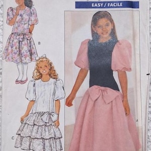 May include: Butterick sewing pattern 4530 featuring three dress designs. The pattern includes a dress with a pink skirt and black bodice, a floral dress, and a white dress with a tiered skirt. The size range is 17-8-10.