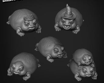 May include: Five 3D printed figurines of frogs wearing different hats. The frogs are all in a sitting position with their mouths open. The hats include a crown, a witch's hat, and a simple cone hat.