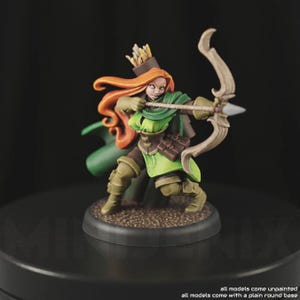 May include: A green and brown painted miniature figurine of a female archer with red hair, wearing a green cloak and holding a bow and arrow. The figurine is standing on a round black base.