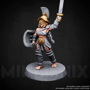 May include: A miniature gladiator figurine, posed with a sword raised and shield at the ready. The figure wears a helmet, armor, and a skirt. The base is a plain, round grey platform. The text at the bottom reads "all models come unpainted".