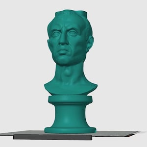 Può includere: Busto turchese di un uomo con espressione seria, montato su un piedistallo. La scultura è un'opera d'arte classica, adatta per la decorazione della casa o dell'ufficio. Il busto è di colore turchese.