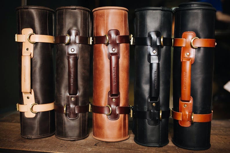 May include: Five leather carrying cases in different colors, brown, black, and tan. Each case has a leather handle and a buckle closure.