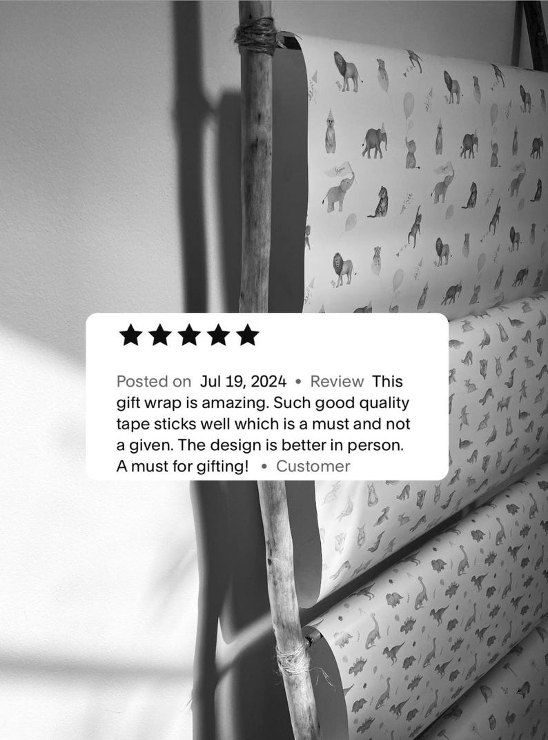 May include: Five rolls of wrapping paper with different animal designs. The designs include a variety of animals, including lions, elephants, giraffes, and dinosaurs. The wrapping paper is white with black and gray animal illustrations. The text on the image reads: "Posted on Jul 19, 2024 Review This gift wrap is amazing. Such good quality tape sticks well which is a must and not a given. The design is better in person. A must for gifting! &bull; Customer"