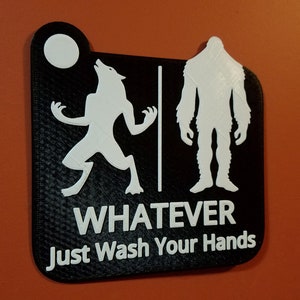 Puede incluir: Un letrero en blanco y negro con una silueta de hombre lobo y un pie grande. El letrero dice "Whatever Just Wash Your Hands".