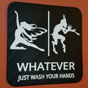 May include: Black and white sign with a fairy and a satyr on either side of a dividing line. The sign reads "WHATEVER JUST WASH YOUR HANDS".