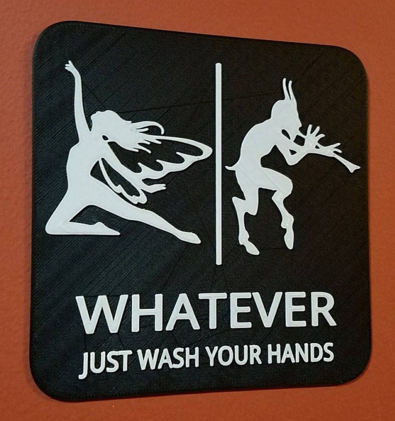 May include: Black and white sign with a fairy and a satyr on either side of a dividing line. The sign reads "WHATEVER JUST WASH YOUR HANDS".