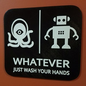 Letrero de baño de género neutro con robot alienígena Lo que sea, lávese las manos