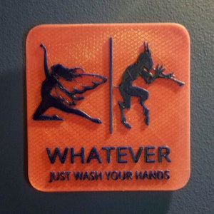 May include: Orange sign with a black silhouette of a winged figure on the left and a horned figure on the right. The sign says "WHATEVER JUST WASH YOUR HANDS".