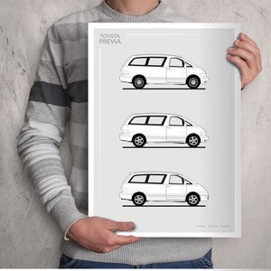 May include: A white poster featuring three line drawings of a Toyota Previa minivan. The text "TOYOTA PREVIA" is at the top. The poster is held by a person wearing a gray and white striped sweater.