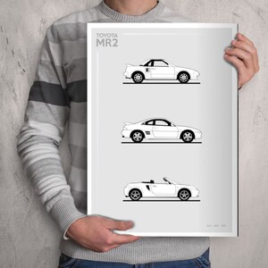 Puede incluir: Una impresión en blanco y negro de tres coches Toyota MR2 diferentes. La impresión tiene el texto "TOYOTA MR2" en la parte superior.