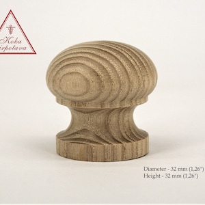 Puede incluir: Un pomo de madera con una parte superior redondeada y una base cilíndrica. El pomo está hecho de madera marrón claro con un patrón de veta natural. Mide 32 mm de diámetro y 32 mm de altura.