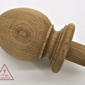 May include: A wooden finial with a rounded top and a cylindrical base. The finial is made of light brown wood with a natural grain pattern.