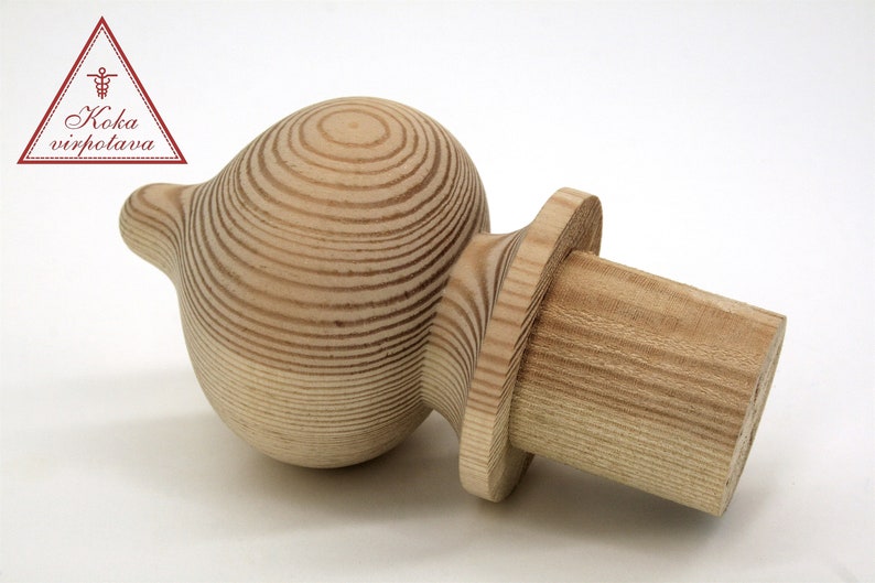 May include: A wooden finial with a rounded top and a cylindrical base. The finial is made of light-colored wood with a grain pattern.