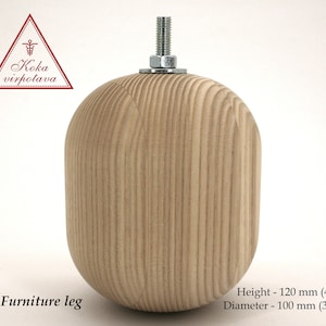 Puede incluir: Una pata de mueble de madera con una parte superior redondeada y un inserto de metal roscado. La pata mide 120 mm de alto y 100 mm de diámetro.
