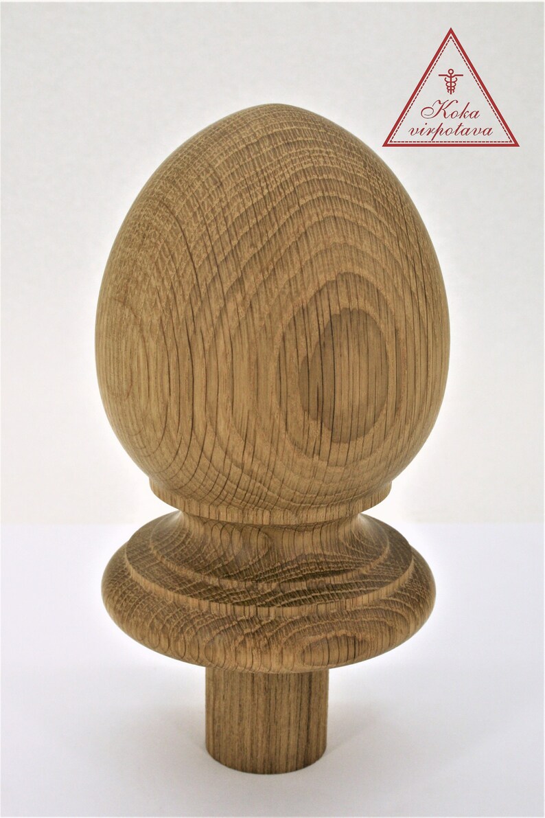 May include: A wooden finial with a rounded top and a base with a decorative edge. The finial is made of natural wood with a light brown colour and a visible grain pattern.