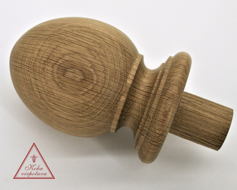 May include: A wooden finial with a rounded top and a cylindrical base. The finial is made of light brown wood with a natural grain pattern.