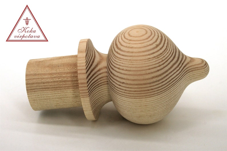 May include: A wooden finial with a rounded, bulbous top and a cylindrical base. The finial is made of light-colored wood with a natural grain pattern.