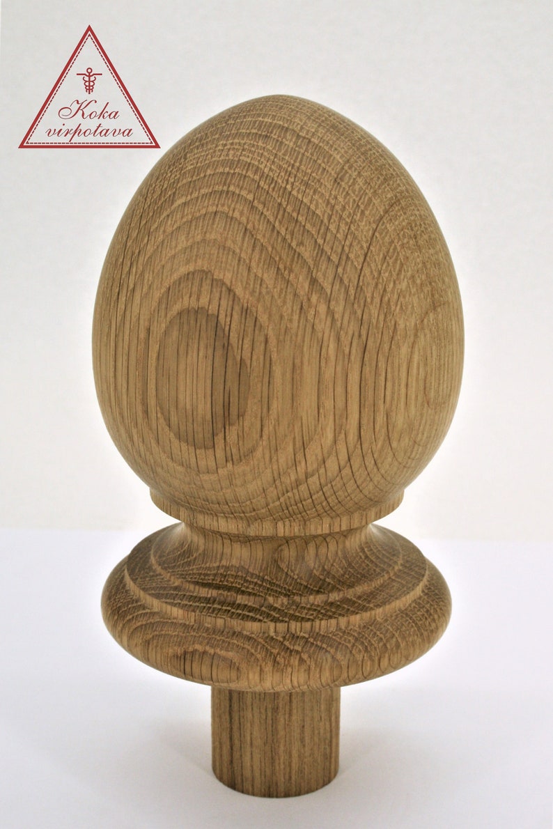 May include: A wooden finial with a rounded top and a base with a decorative ring. The finial is made of light brown wood with a natural finish.