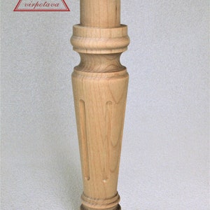 May include: A wooden furniture leg with a turned design and a rounded bottom. The leg is light brown in color and has a smooth finish.