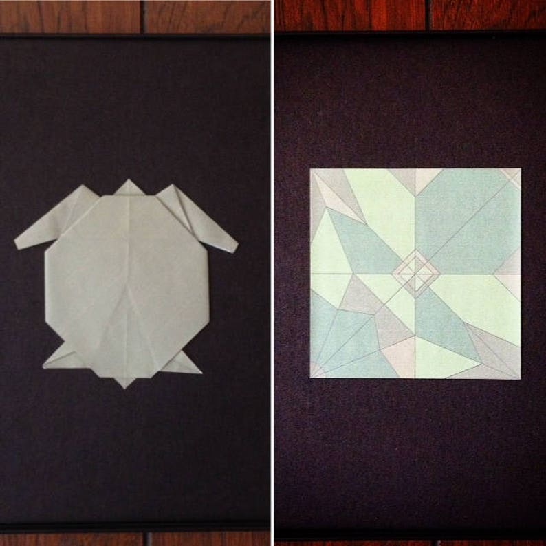 May include: Two origami figures on a black background. The figure on the left is a grey origami turtle. The figure on the right is a green, blue and white origami flower.
