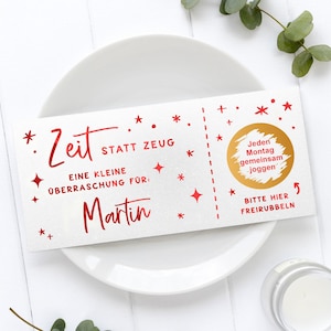 May include: A white gift certificate with red text and star accents. The text reads "Zeit statt Zeug" and "Eine kleine &Uuml;berraschung f&uuml;r: Martin". A gold circle says "Jeden Montag gemeinsam joggen".